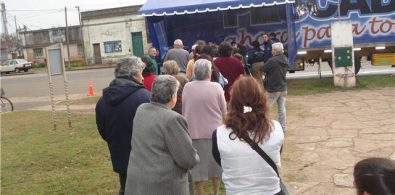 La gente espera por la merluza en Plaza Belgrano.